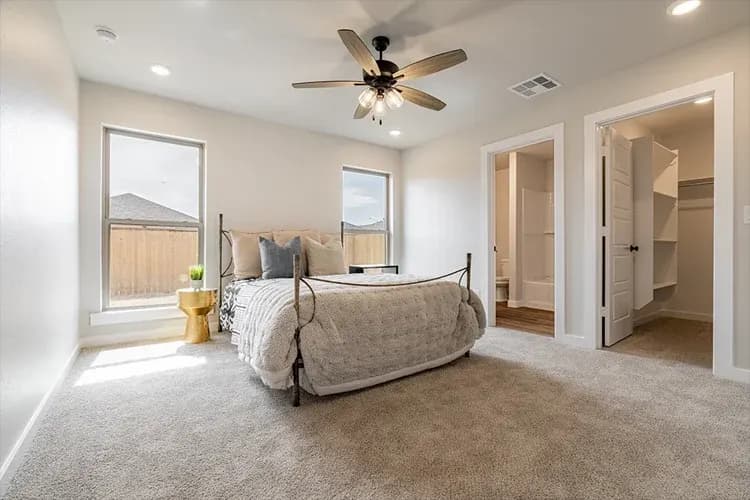 Primary bedroom, alternate staging, with ensuite bath and closet in The Clear Creek home model by Buffalo Built LLC.
