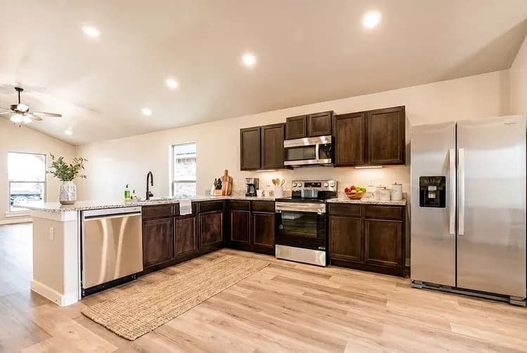 Kitchen with refrigerator and appliances in The Meadow Lark home model by Buffalo Built LLC.
