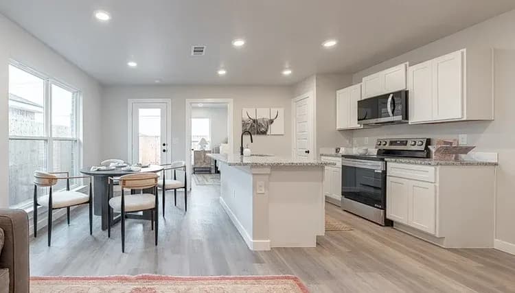 Kitchen island with dining table in The Piney Creek home model by Buffalo Built LLC.