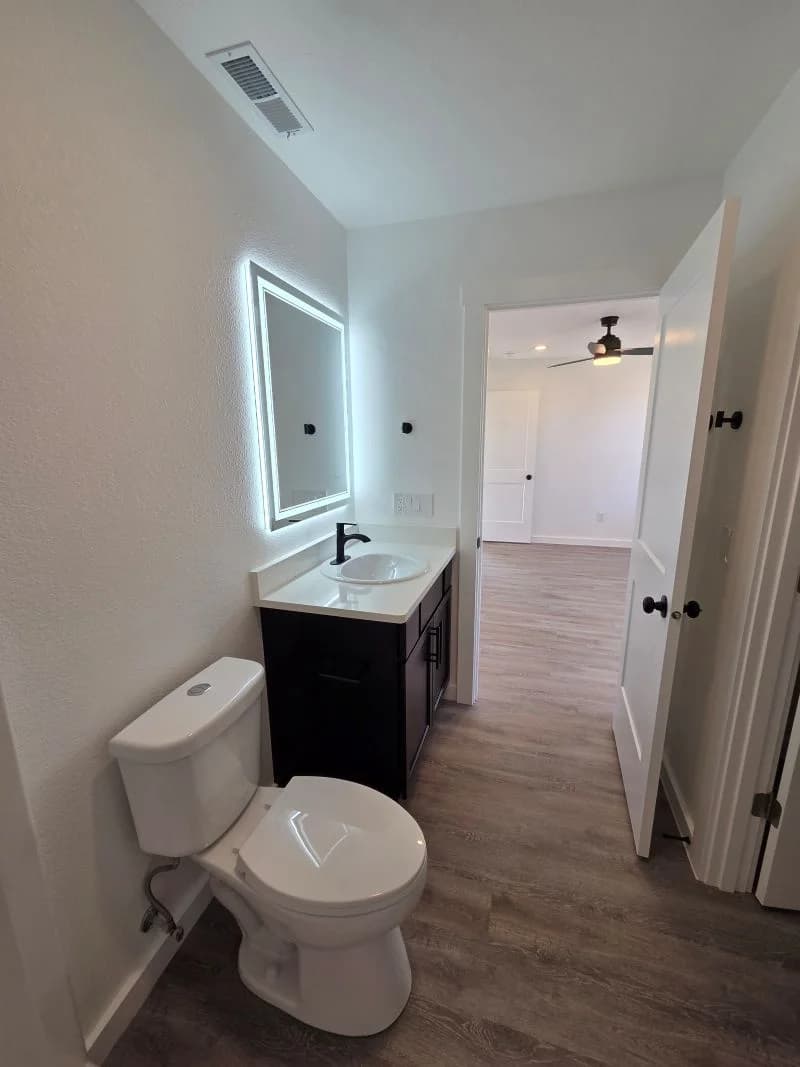 Bathroom vanity with illuminated mirror in the finished Tie Hack completed home