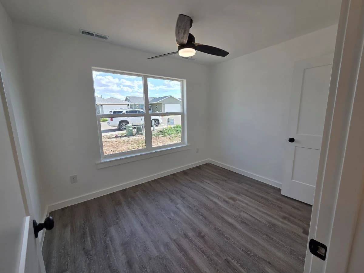 Bedroom 2 with large window in the finished Tie Hack completed home