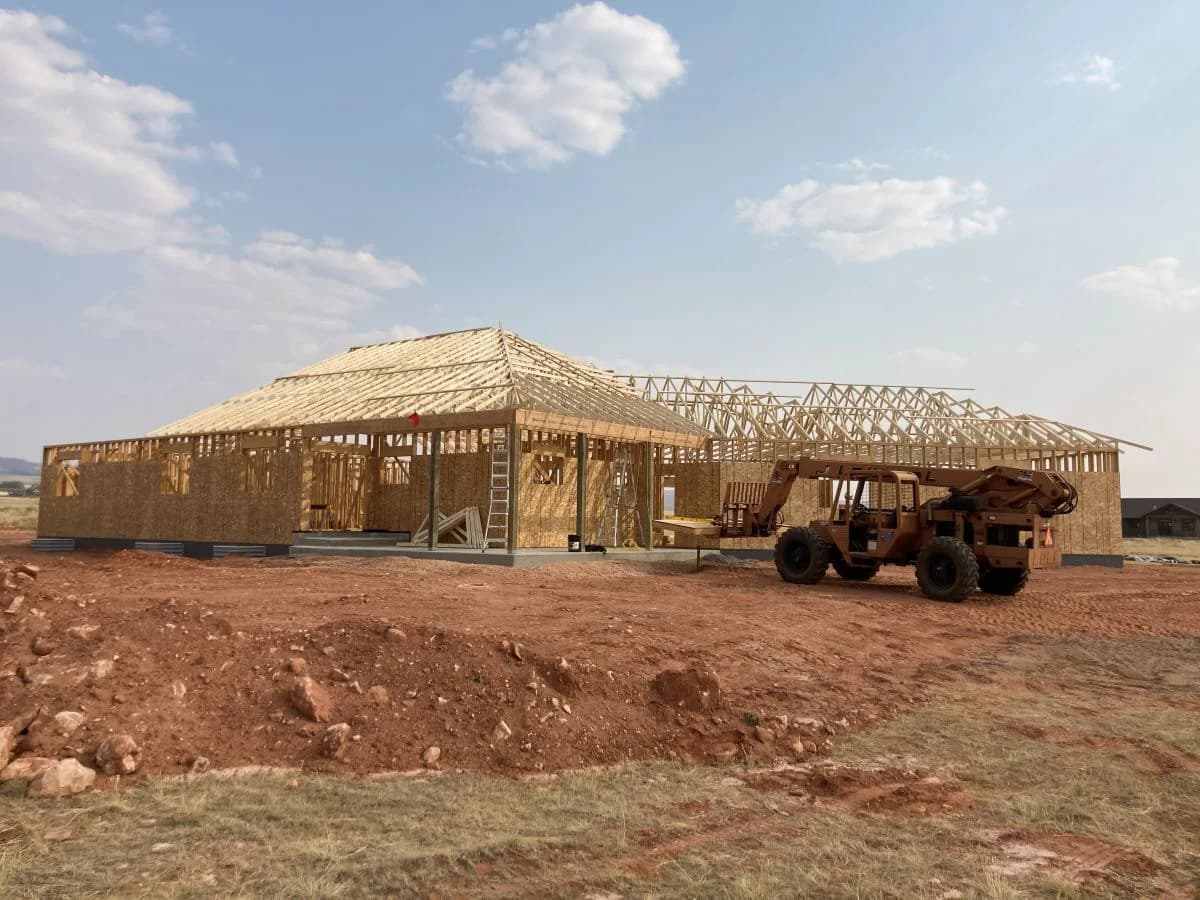 Custom home framing with roof trusses set by Buffalo Built LLC in Wyoming.