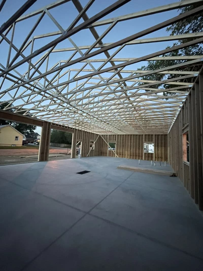 Garage framing in progress with roof trusses set by Buffalo Built LLC in Wyoming.